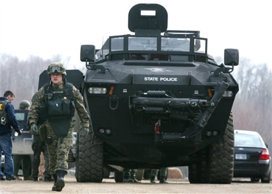 Police set up a staging area across from the home in Hillsdale County, Mich., where a fugitive member of the Hutaree militia was holed up on Monday.